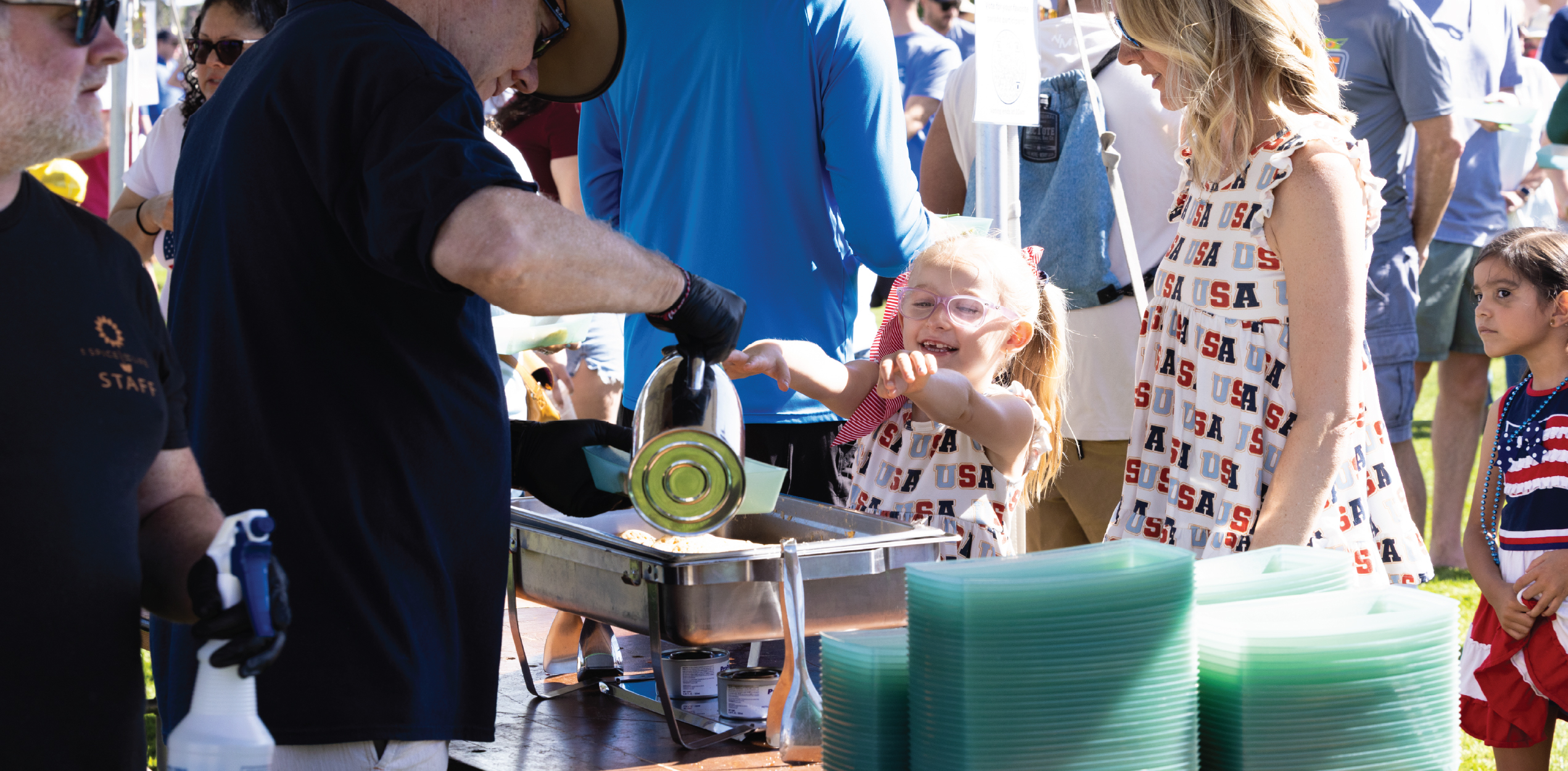 Child happily grabbing pancakes during the festival.
