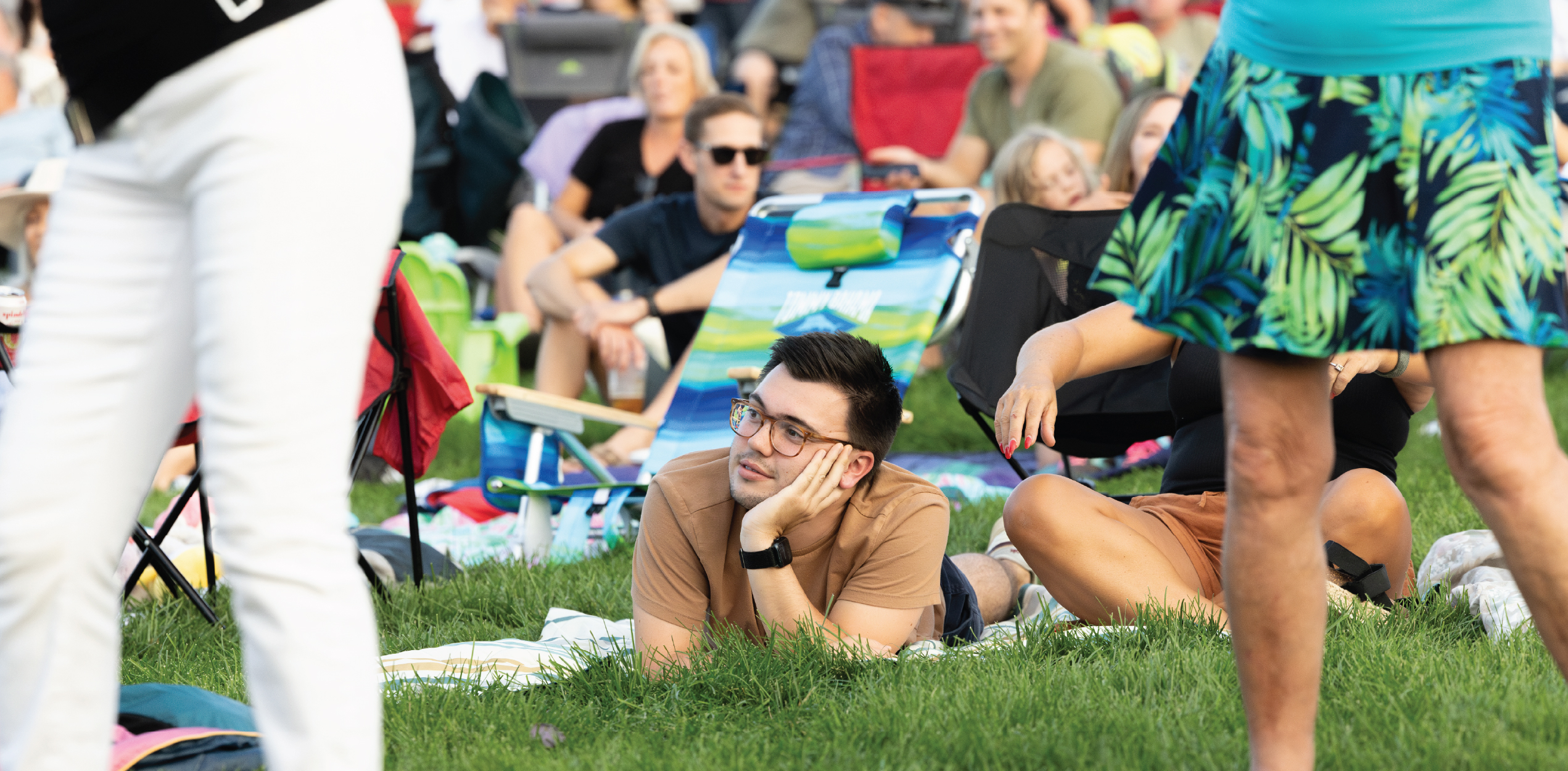 Person laying on a picnic blanket with a very content look on their face.