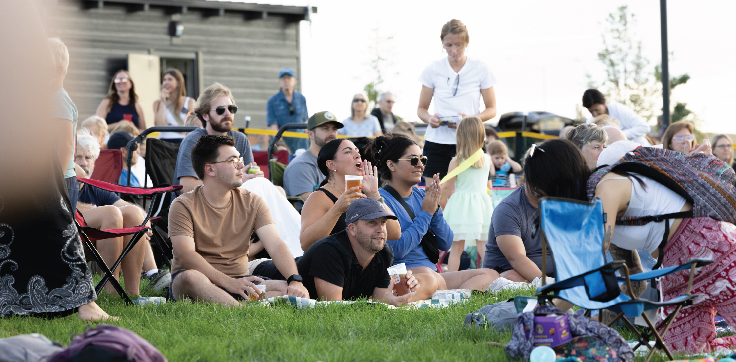Group of friends huddled on a picnic blanket getting into the music.