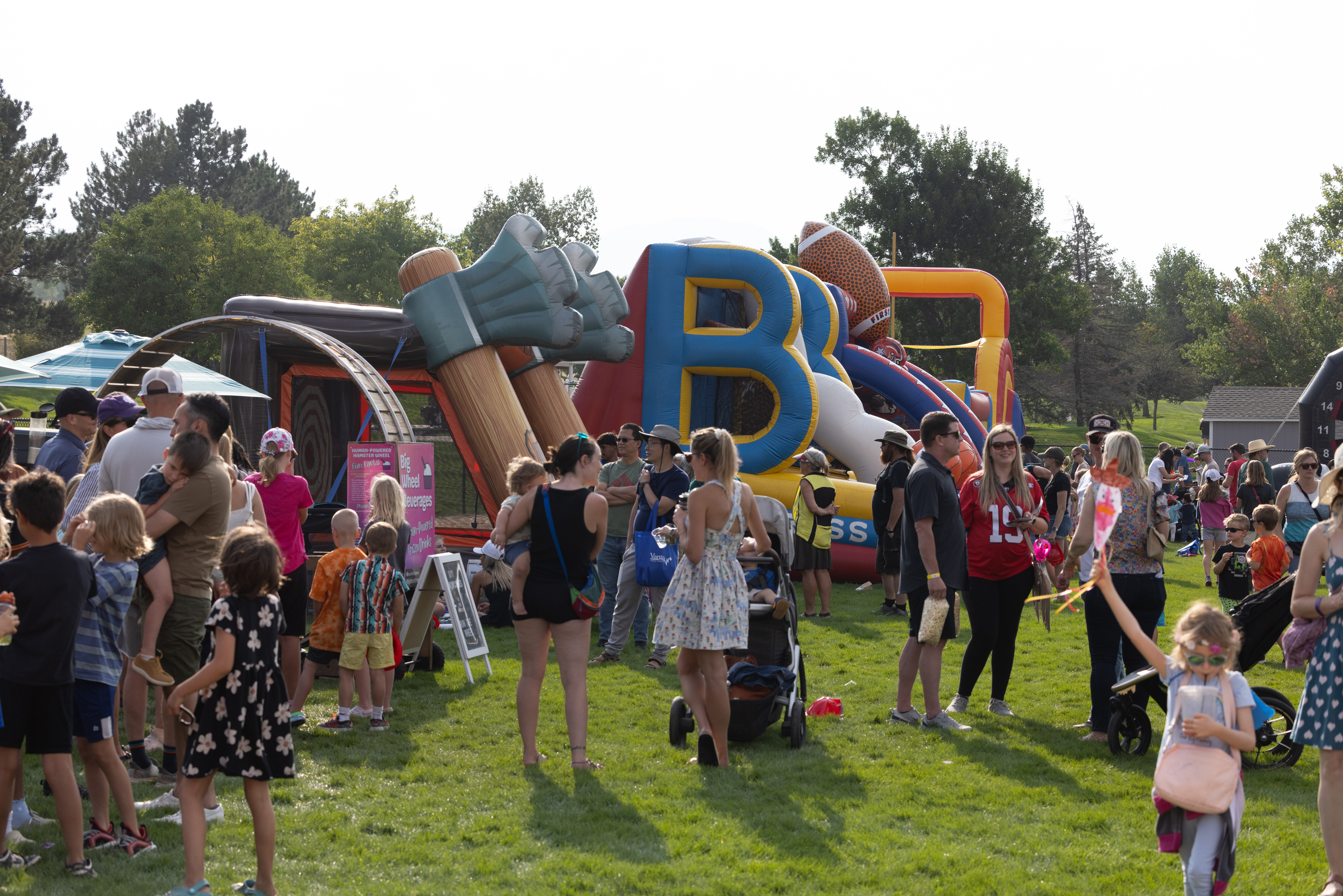 Large group of people playing a variety of carnival style games.