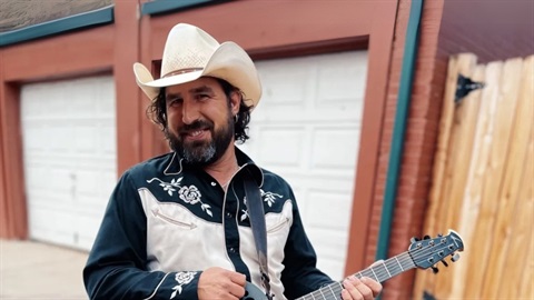 Aaron Rose holding a guitar