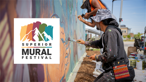 Superior Mural Festival logo over a photo of someone painting a mural on a wall