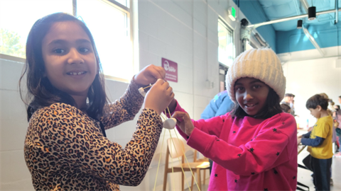Two young girls make something out of marshmallows at Stem-A-Thon