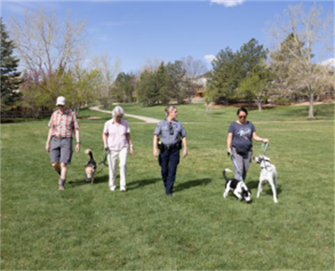 Four people stand with dogs on leash