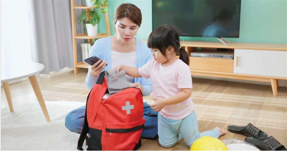 Woman & child with a red backpack preparing for emergencies