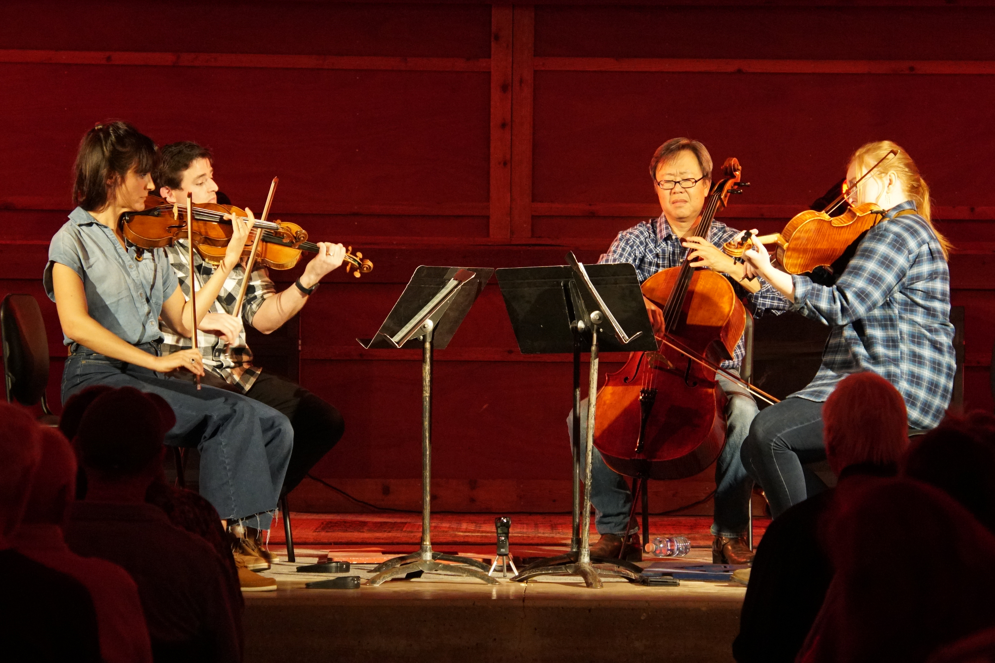 boulder phil-americana: 4 musicians playing violin-shaped instruments in a circle around a music stand
