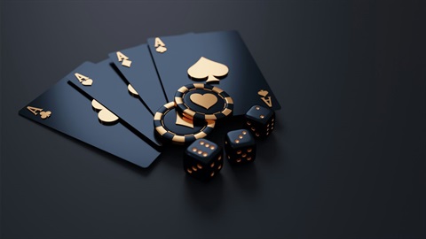 Close-up image of black & gold playing cards (4 aces), 2 poker chips, & 3 dice