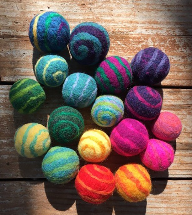pile of multi color felt yarn balls on wooden background